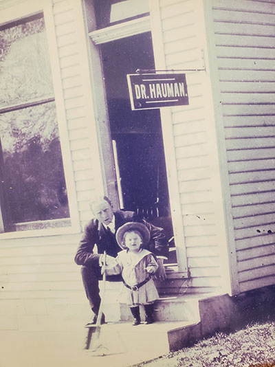 The historic Dr. Hauman medical office, with an earlier Dr. Hauman and a child on the front steps
