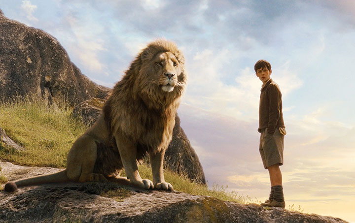 A Boy Stands Beside a Lion